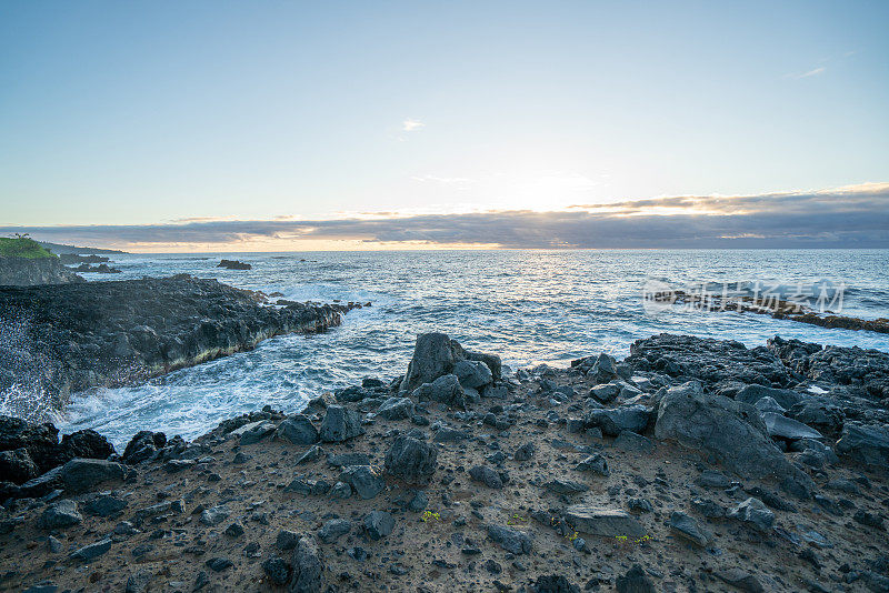 日出时的岩石海岸线，海浪拍打着夏威夷毛伊岛的悬崖