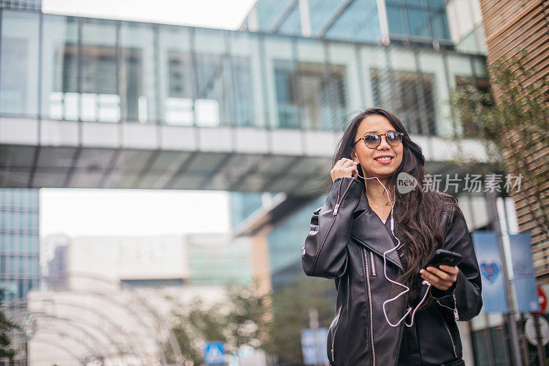 年轻女子在街上听音乐