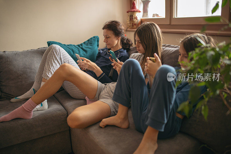 在客厅沙发上使用手机的家庭