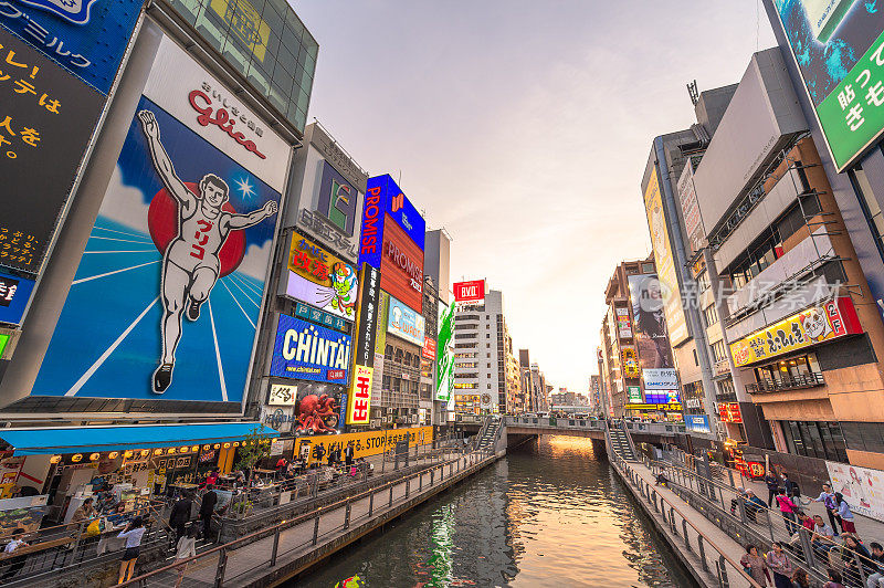 在日本大阪的道顿堀，五颜六色的广告牌照亮了大阪夜市周围的商店和零售店