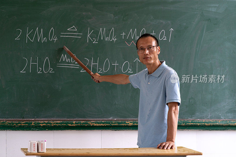 亚洲中年男教师在黑板前演讲