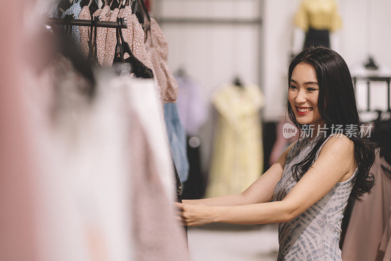 亚洲华人女性在服装零售店购物和浏览