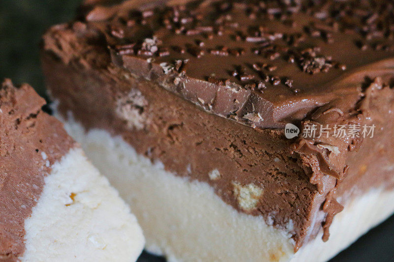 这是自制巧克力和椰香香草冰淇淋中的棕色和白色薄片的特写图像