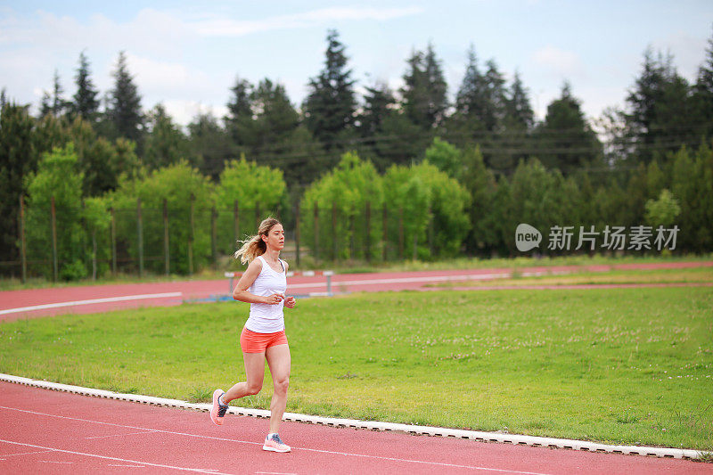 女子短跑运动员在体育场跑步。