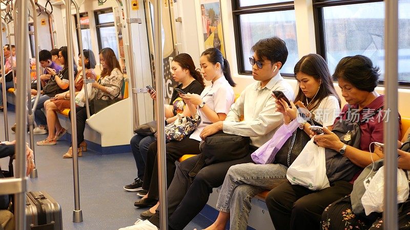 泰国人在火车上使用智能手机。公共交通。