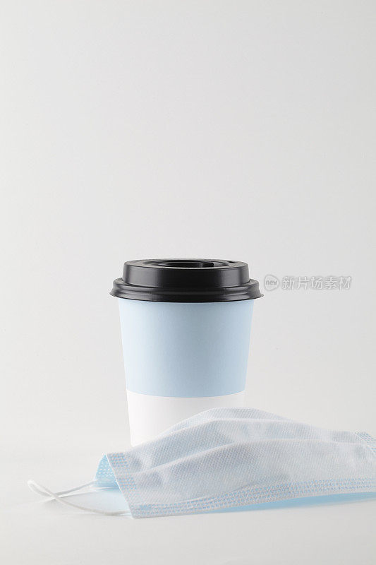 带医用口罩的白底咖啡或茶，可取纸杯