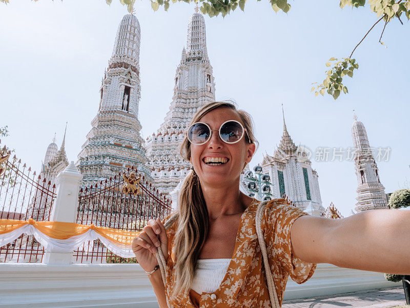 快乐的女人在泰国与佛像自拍