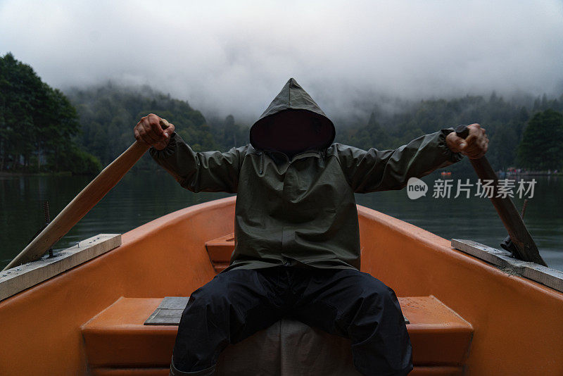 人在湖上钓鱼，从船雨衣船神秘危险