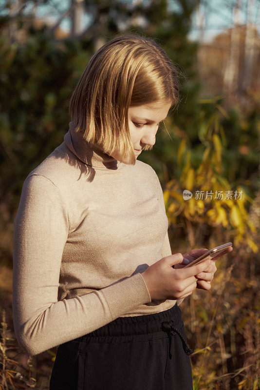一个十几岁的女孩在看智能手机短信