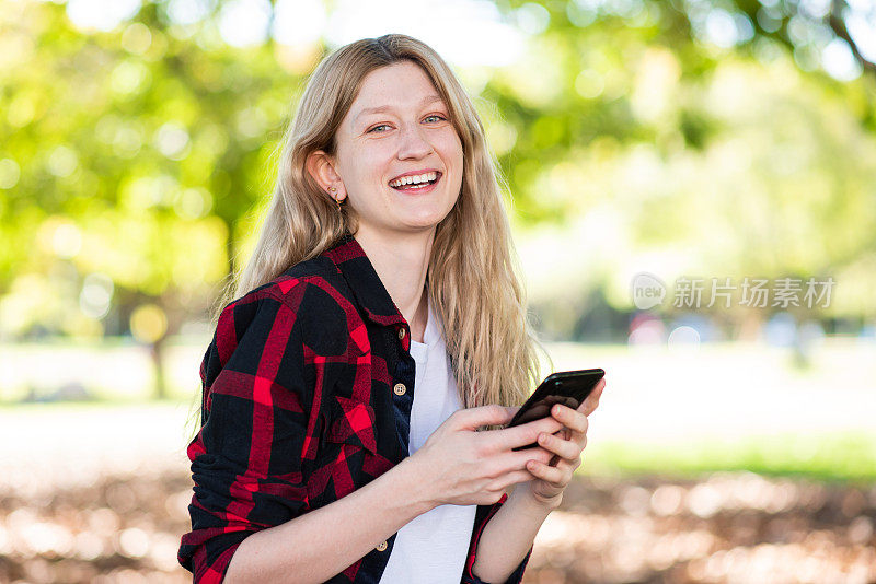 一个金发女人在用智能手机发短信