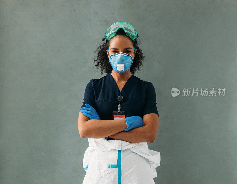 墙上年轻护士的画像。女医学专家双臂交叉站着。
