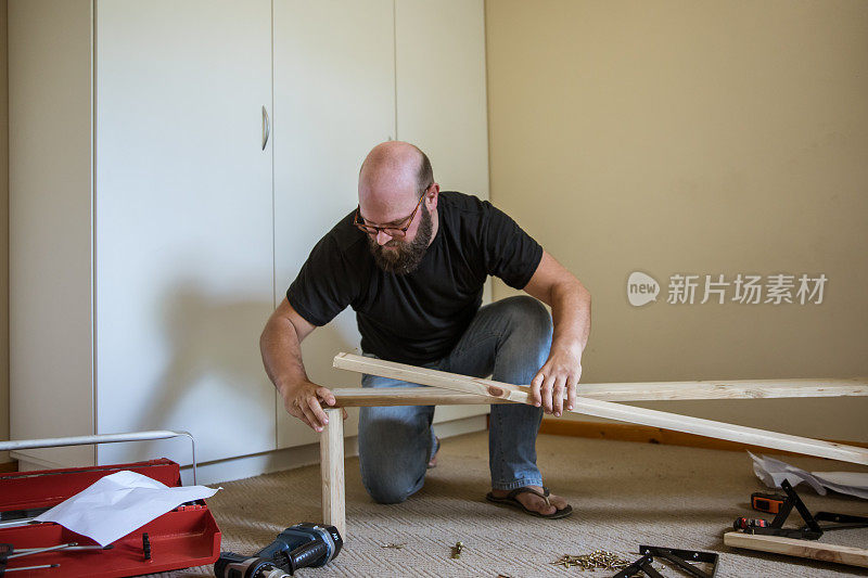 中年男性在家里忙着自己动手做木工