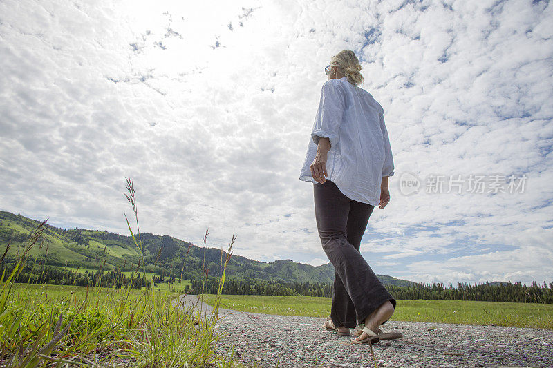 清晨，女人走过小径，穿过草地