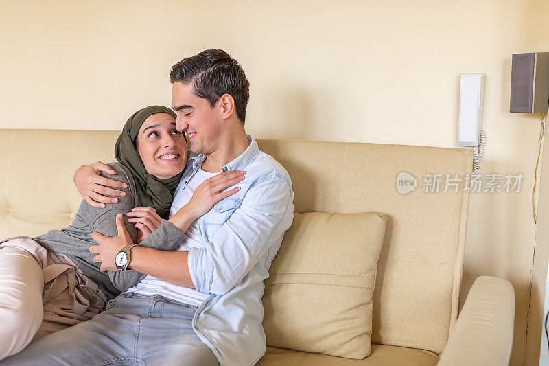 一位年轻的穆斯林妇女正在与她英俊的男朋友在家里分享快乐。