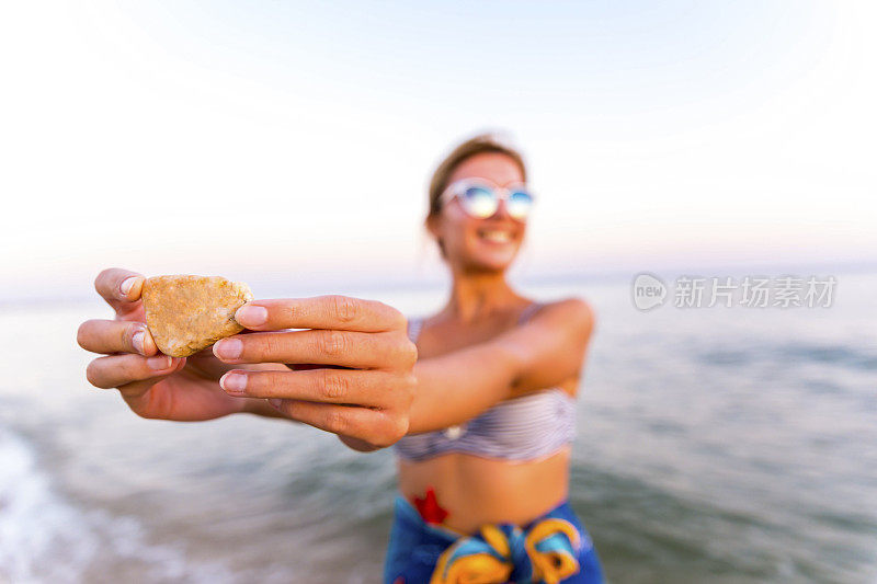 在海滩上拿着石头的女人