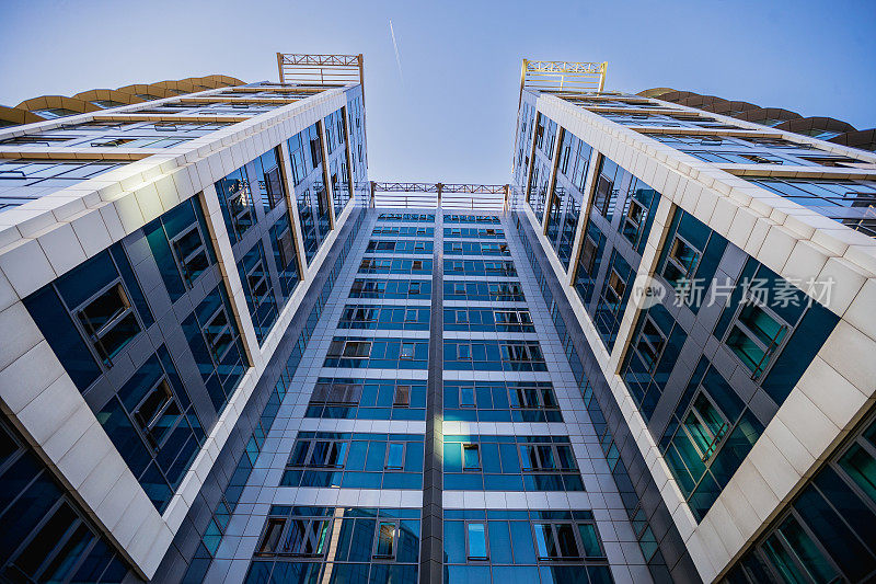 蓝色玻璃和混凝土砌块的企业建筑外观的低角度视图
