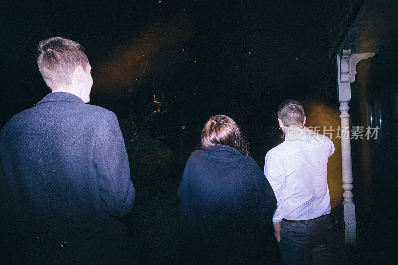 一群朋友站在外面看新年烟花