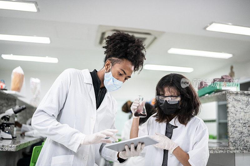 学生在实验室里做实验和使用数码平板电脑