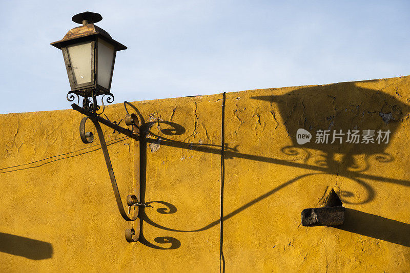 墨西哥圣米格尔德阿连德，殖民时期建筑立面上的路灯，投下长长的影子