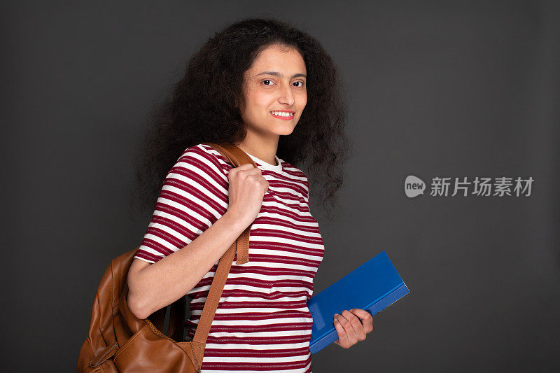 年轻女孩学生的肖像持有笔记本和有背包库存的图像