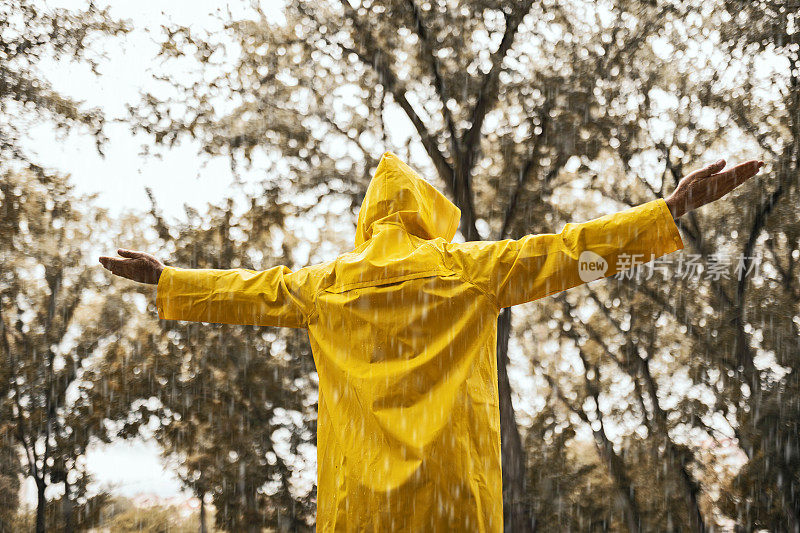 长者伸开双臂享受雨天