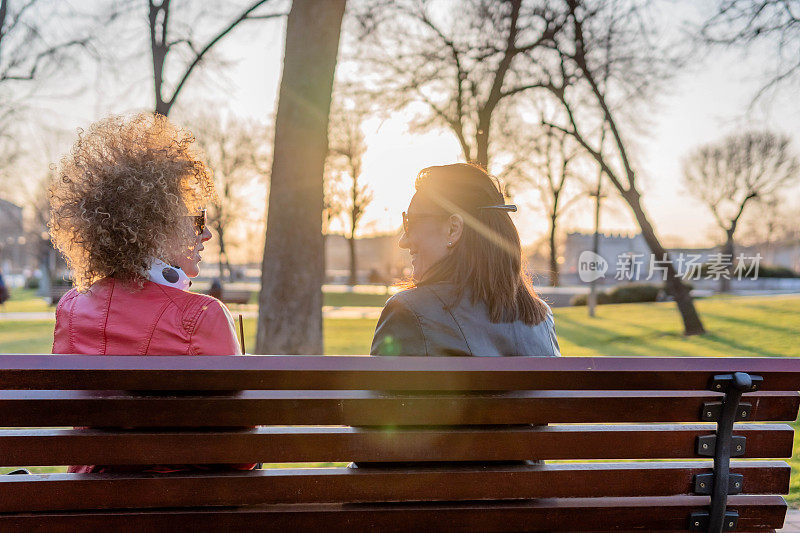 女性朋友坐在公园的长椅上