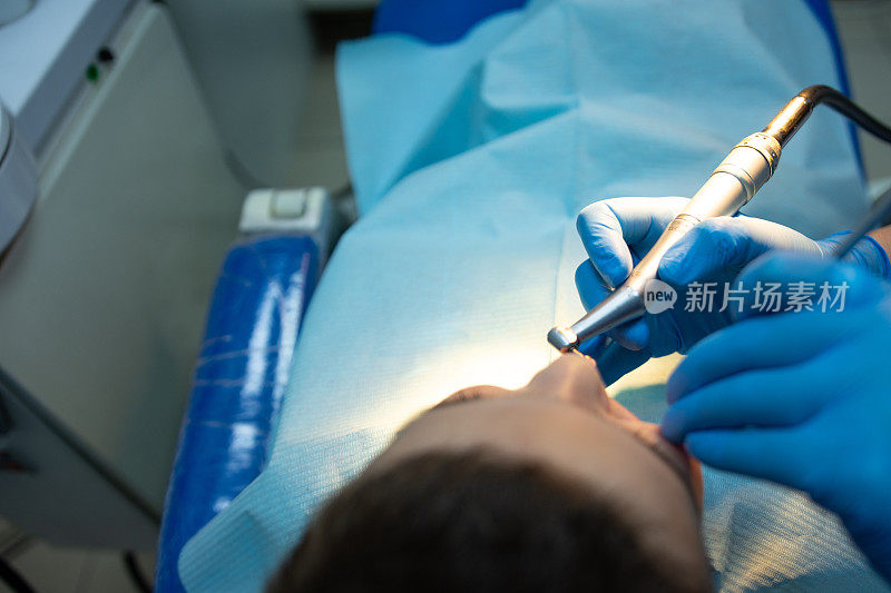 牙科医生检查坐在牙科椅子上的儿童牙齿