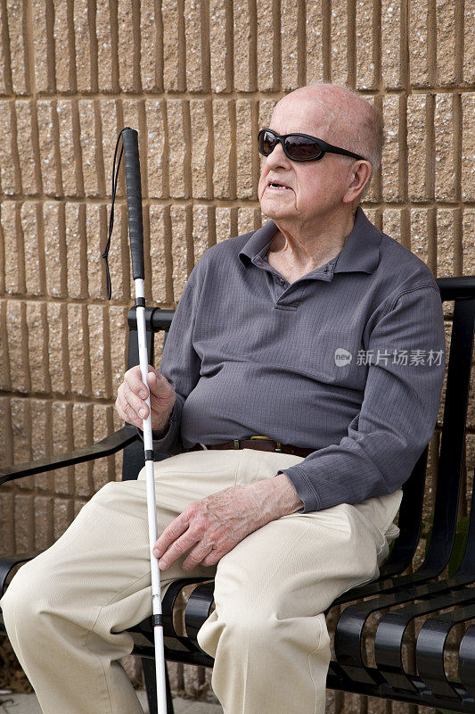盲人坐在长凳上