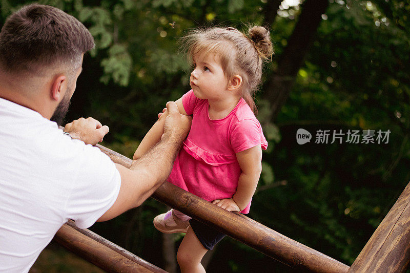 这是爸爸和女儿在操场上玩耍的好日子