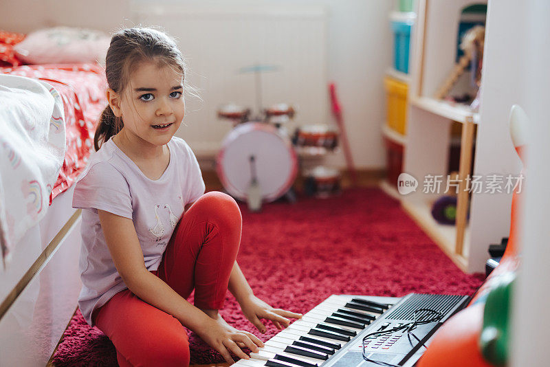 小女孩一边玩一边学习乐器