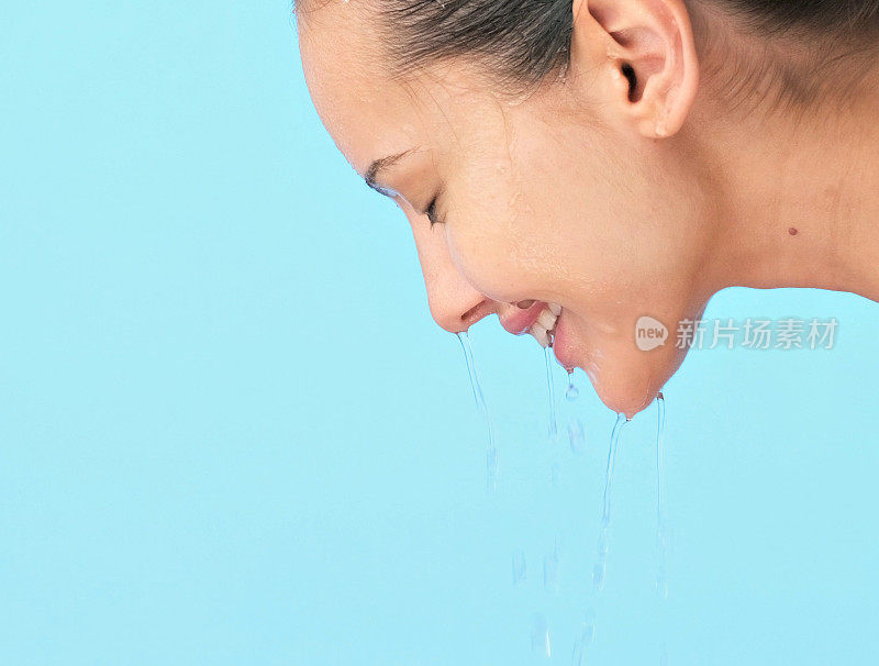 女性脸上有水。年轻快乐的女孩，脸上淌着水。女子用水洗干净的脸。