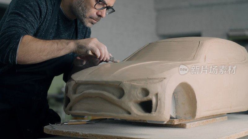 汽车设计师使用塑形工具对汽车模型进行塑形