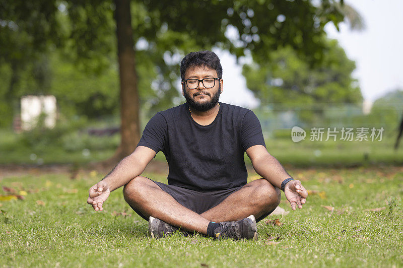 一名年轻人在公园里练习瑜伽和冥想