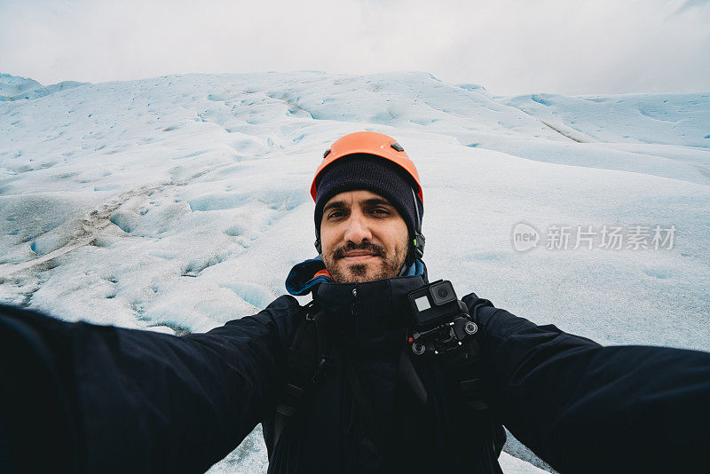 一名年轻男子在莫雷诺冰川徒步旅行期间自拍。他戴着头盔。观点的看法。