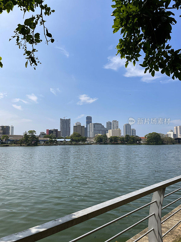这是斯里兰卡首都科伦坡的城市，周围是金属安全屏障，贝拉湖，背景是科伦坡世界贸易中心(WTC)的双塔，前景是焦点