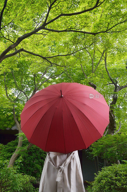 拿着红色雨伞的女人