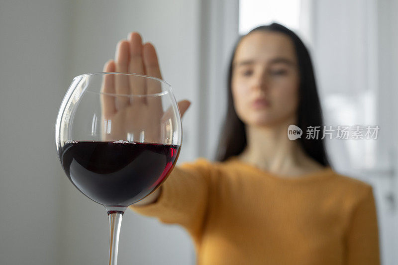 女人做了一个手势，表示他拒绝喝酒