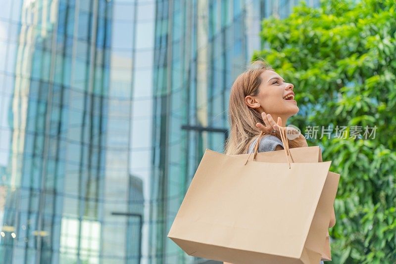 优雅的女商人在金融区拎着购物袋