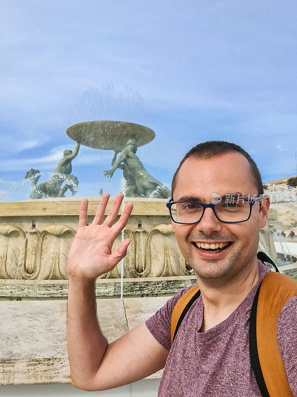 一名年轻人在马耳他瓦莱塔的Tritons喷泉前自拍