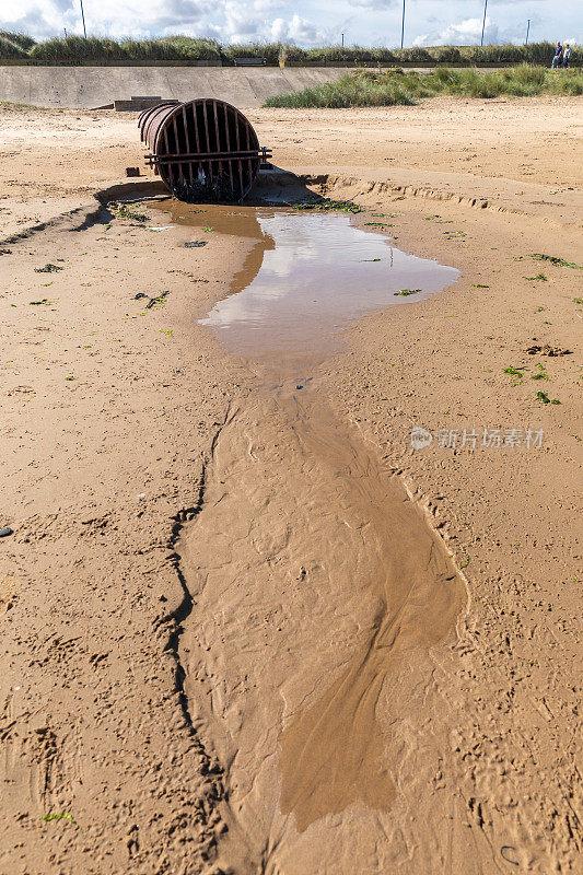 英国约克郡海岸沙滩上，涨潮处的污水或雨水溢流管道出口