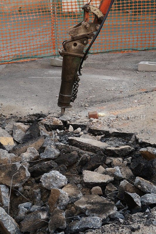 道路施工现场。用手提钻拆除道路上的沥青。