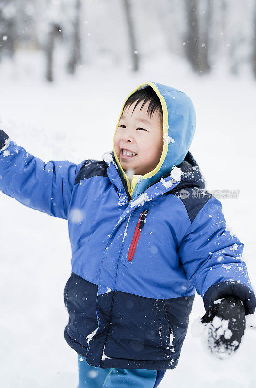 冬天，小男孩在户外的雪地里坐雪橇