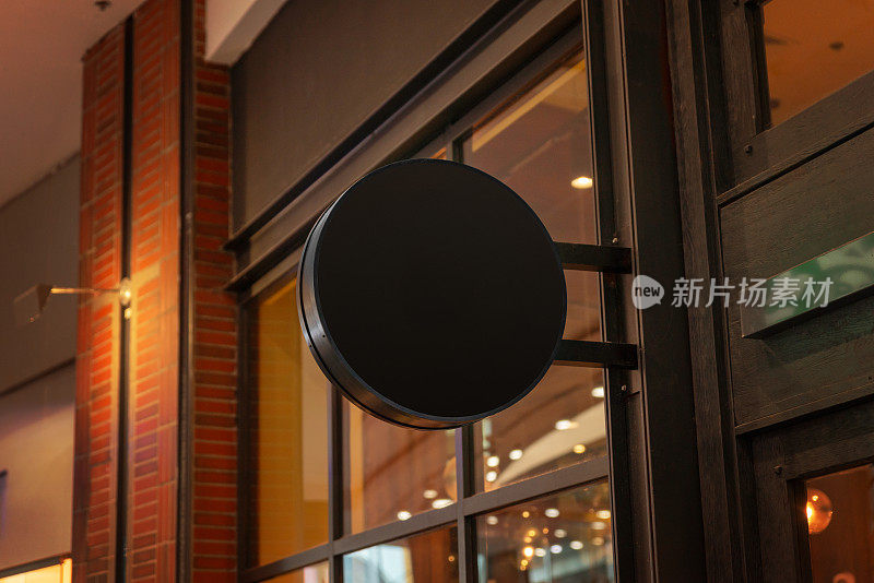 商场内的黑色圆形logo推广标牌，提供时尚醒目的展示，吸引顾客，提高品牌知名度