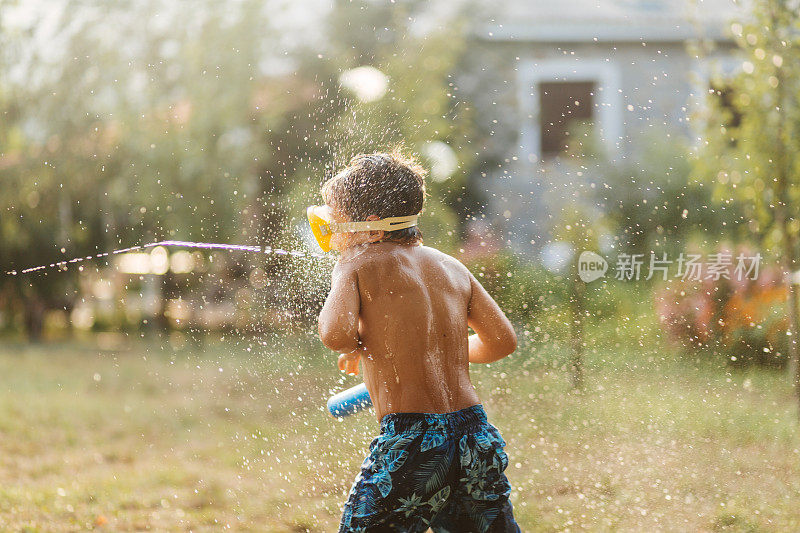 炎热的夏日，孩子们在院子里打水仗