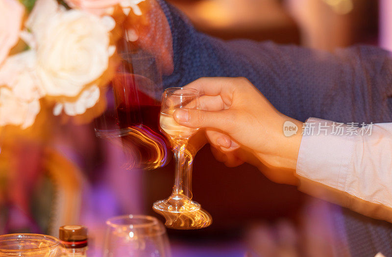 人，节日，饮料和庆祝的概念-近距离的人与一杯酒在餐厅