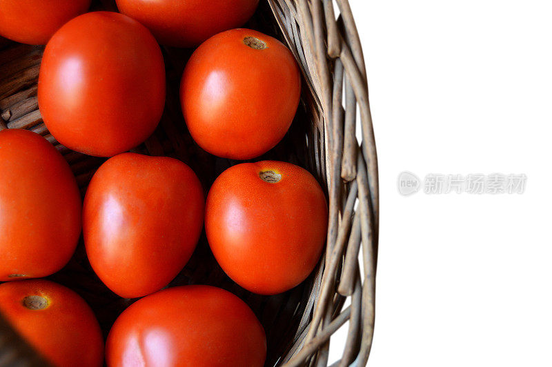 切出的堆许多几个红色成熟的西红柿在一个棕色的木制柳条篮子隔离在水平透明的白色背景，留下复制空间，适合蔬菜，素食食品农贸市场相关的海报，背景