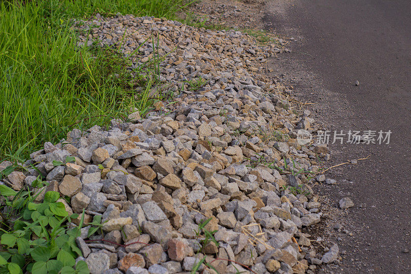 铺好的道路边上的石头是筑路时遗留下来的