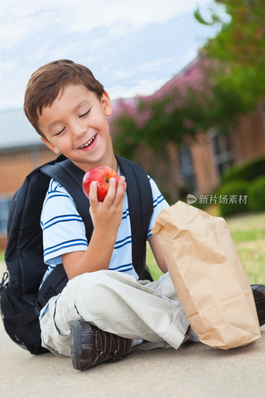 小男孩笑着看着他的学校午餐