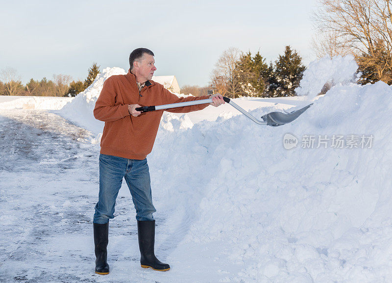 一位老人在雪地里挖完了车