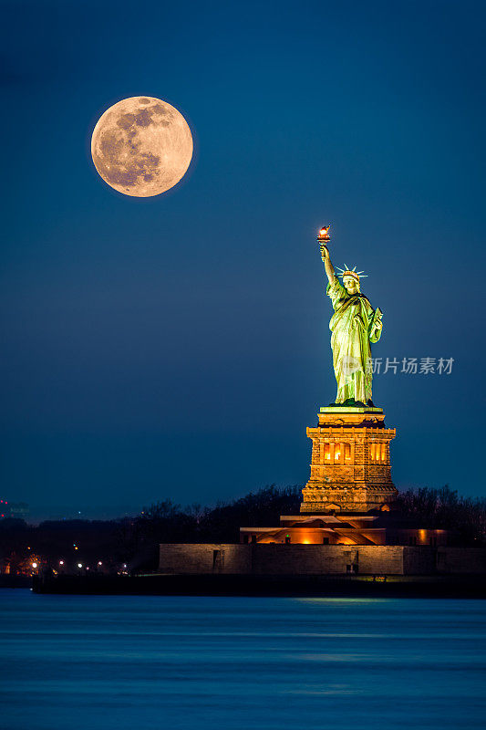 自由女神像和升起的超级月亮